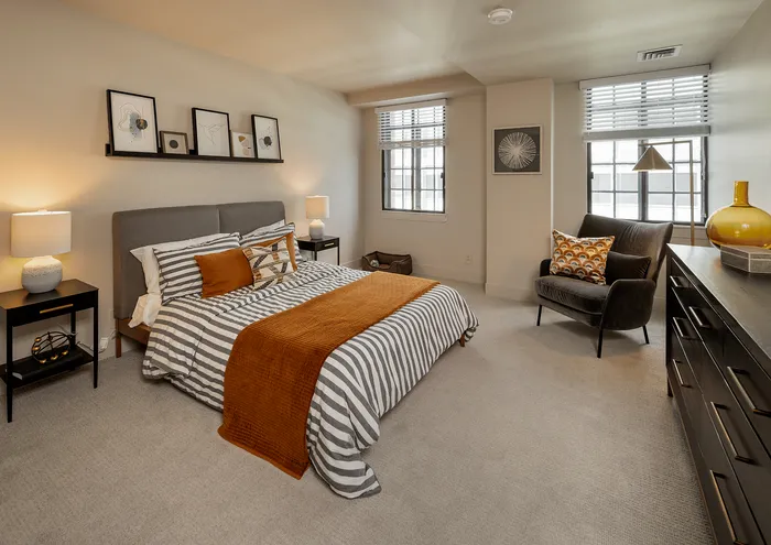 Contemporary bedroom with cozy striped bedding and chic decor.