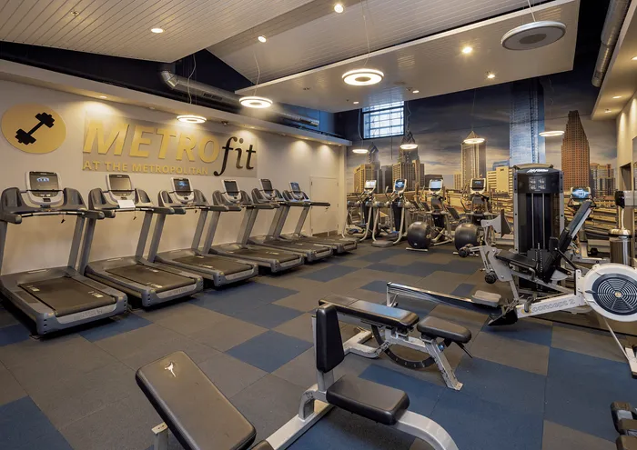 Modern fitness center with treadmills, exercise bikes, and weight machines under sleek lighting.