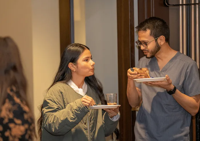 Two people enjoying a casual meal in a cozy apartment setting.