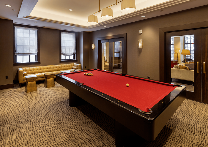 Elegant recreation room with a red pool table and comfortable seating area.