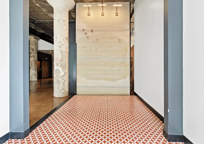 Stylish lobby entrance of The Chester Apartments featuring modern decor and vibrant geometric flooring.