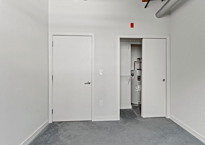 Modern apartment utility closet with clean design and water heater.