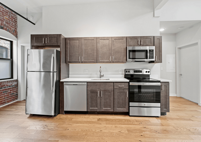 Contemporary kitchen with stainless steel appliances and wooden cabinetry.
