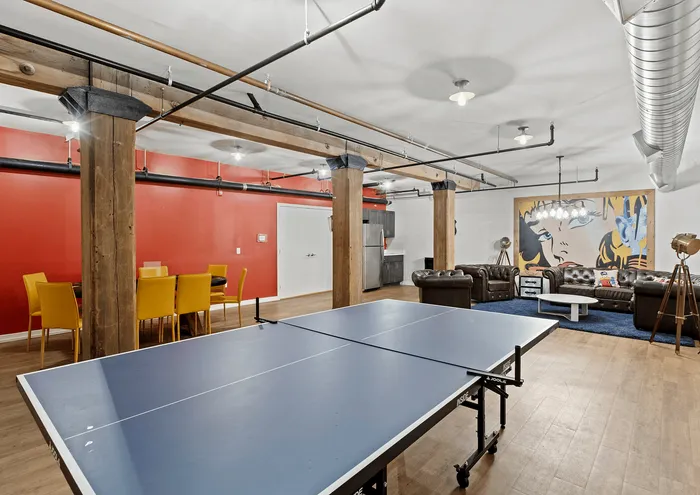 Contemporary loft with ping pong table, vibrant seating, and chic decor.