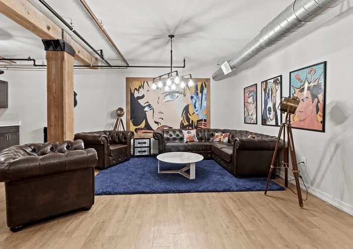 Stylish living room with leather sofas, pop art, and modern lighting in an urban apartment.
