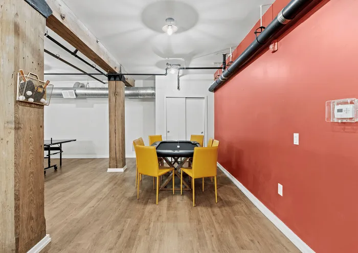 Modern dining area with yellow chairs and industrial elements in a loft-style room.