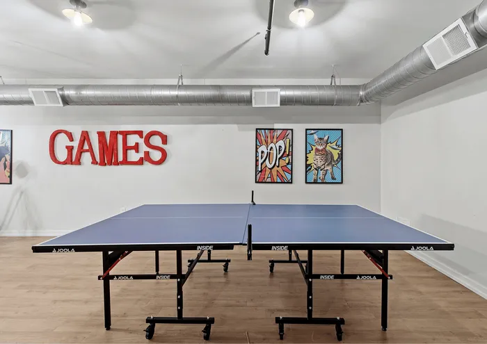 Contemporary game room with ping pong table, artistic wall decor, and bright atmosphere.
