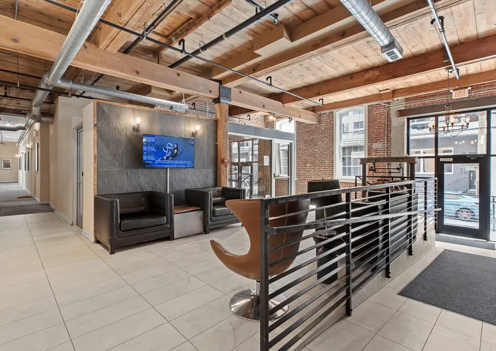 Stylish urban loft reception area with rustic brick walls, modern furniture, and natural light.