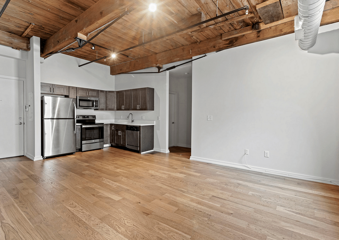 Open-concept kitchen in a modern loft with wooden ceilings and sleek appliances.