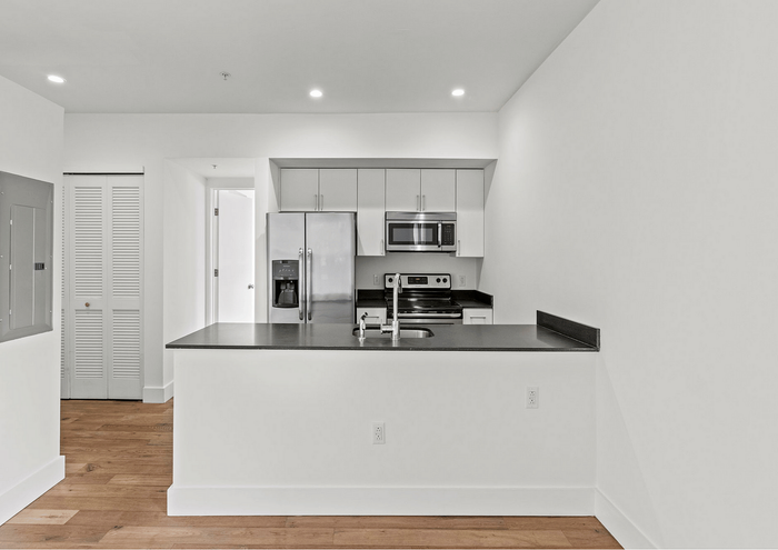 Bright and stylish kitchen with stainless steel appliances, sleek countertops, and white cabinetry.
