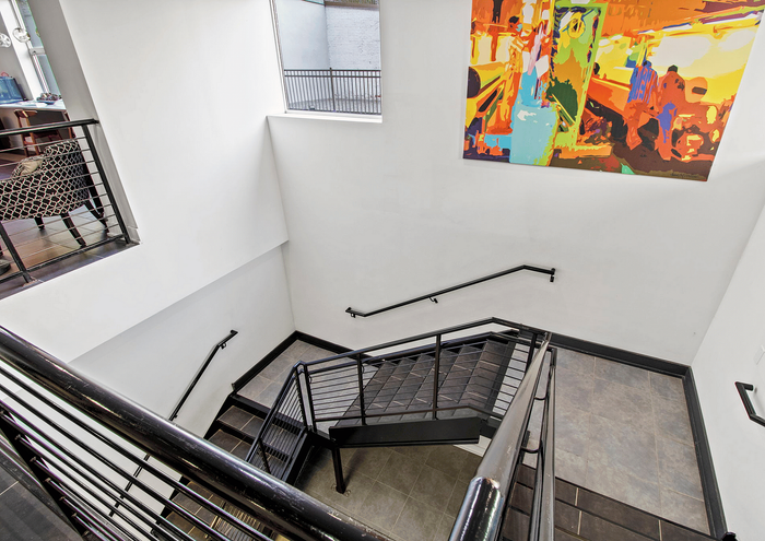Contemporary staircase with sleek black railings and vibrant abstract wall art.