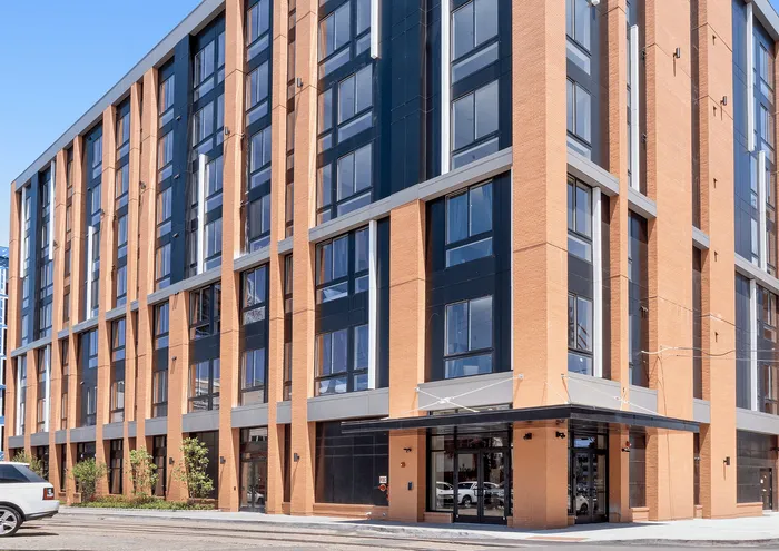 Contemporary brick apartment building with large windows and sleek design.
