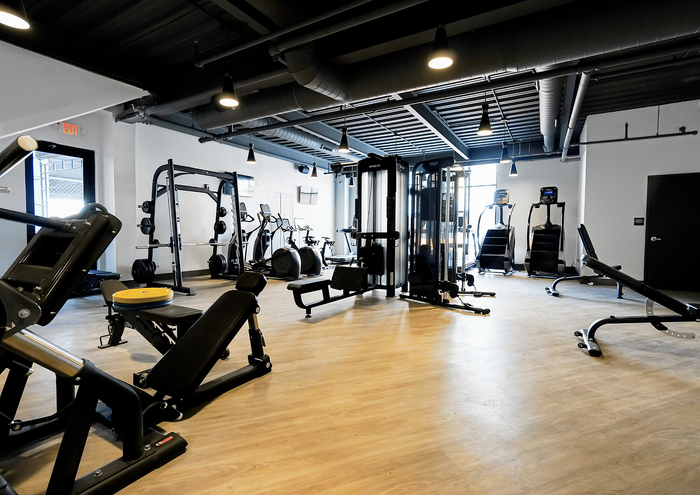 Spacious modern fitness center equipped with state-of-the-art exercise machines and free weights.