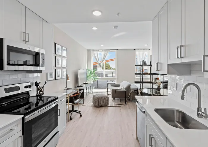 Bright open-concept kitchen and living room with modern appliances and stylish decor.