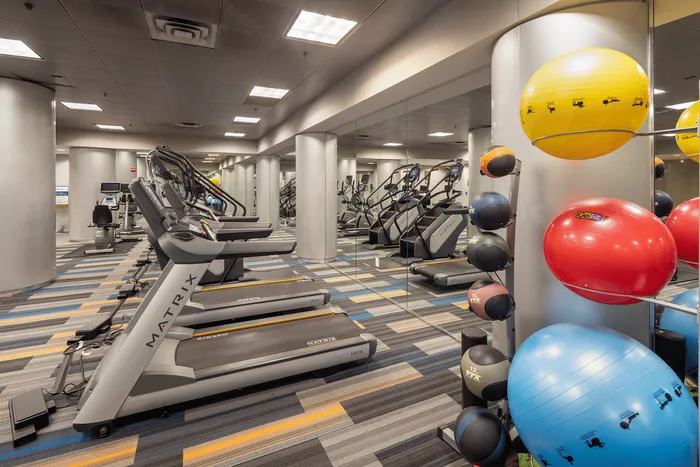 Modern fitness center with state-of-the-art treadmills, colorful exercise balls, and a mirrored wall for an expansive feel.