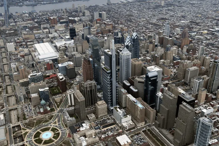 Breathtaking aerial view of a vibrant cityscape with modern skyscrapers and a picturesque river backdrop.