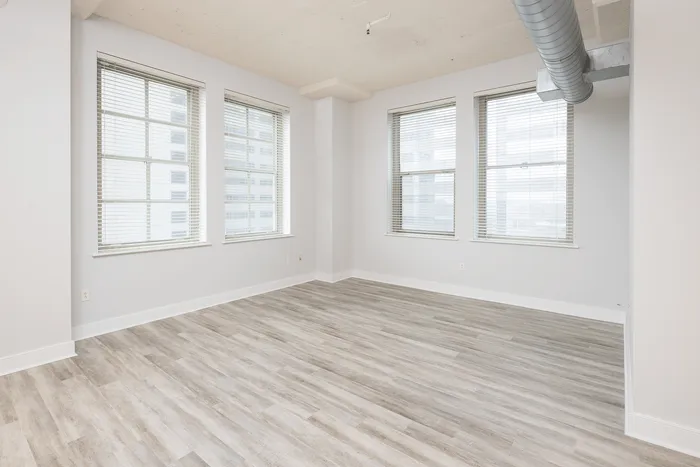 Bright and modern apartment showcasing elegant hardwood floors and expansive windows for natural light.