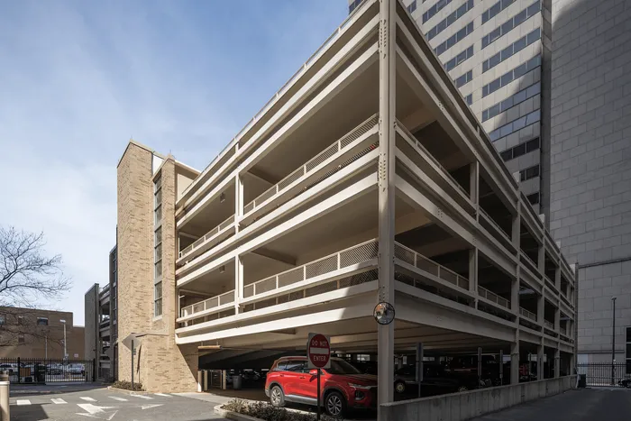 Modern multi-level parking structure with sleek architectural design, offering ample parking space in an urban setting.