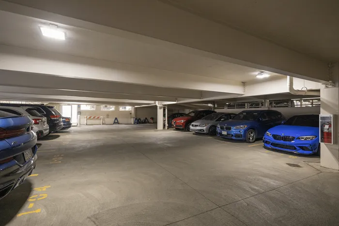 Spacious and well-lit underground parking garage with premium car parking spaces.