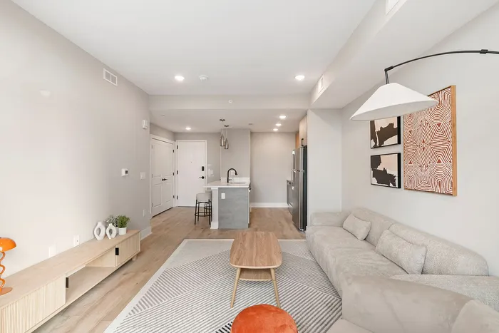 Contemporary open-concept living space with sleek design, featuring a modern kitchen, cozy seating area, and stylish decor.