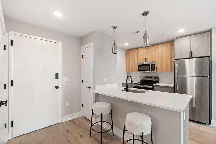 Modern kitchen with sleek appliances, chic lighting, and cozy bar seating.