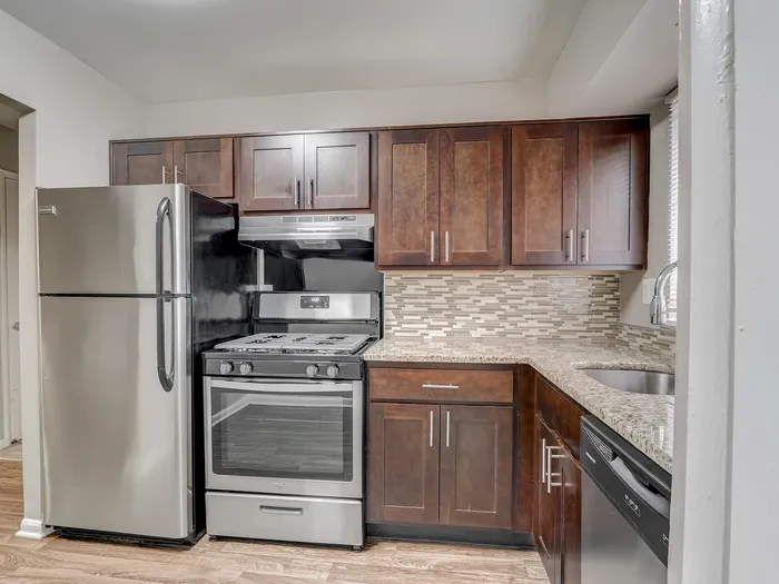 Modern kitchen with stainless steel appliances, granite countertops, and elegant wood cabinetry, offering a stylish and functional cooking space.