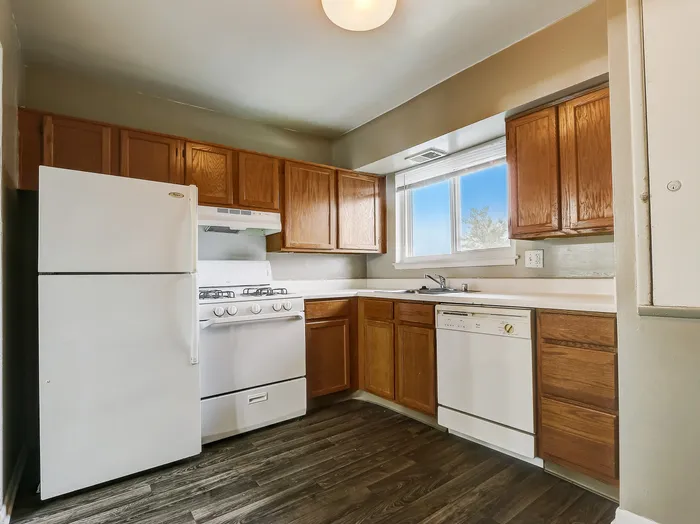 Bright and inviting kitchen with modern appliances, wooden cabinetry, and a large window offering a scenic view.