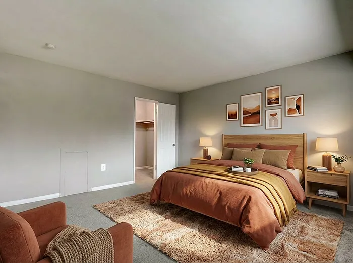 Inviting bedroom with cozy earth-toned decor, showcasing a plush bed, elegant wall art, and a spacious walk-in closet for ultimate comfort.