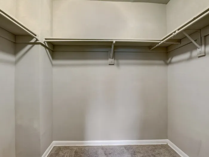 Spacious walk-in closet with ample shelving, perfect for organization and storage.