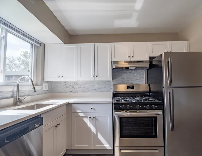 Bright, modern kitchen with sleek stainless steel appliances, elegant white cabinetry, and ample natural light.