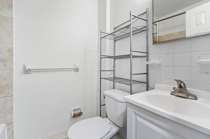 Bright and modern bathroom with sleek fixtures, spacious shelving, and minimalist design.