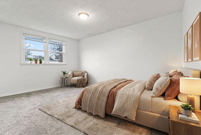 Bright and cozy bedroom with plush bedding, soft carpet flooring, and large windows bringing in ample natural light.