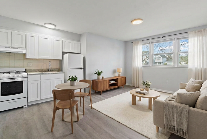 Bright and airy living space with modern kitchen, cozy seating area, and charming dining nook, featuring large windows and stylish decor.