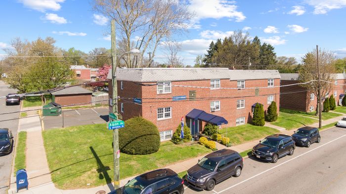 Charming brick apartment complex with well-maintained landscaping and ample parking in a peaceful suburban neighborhood.