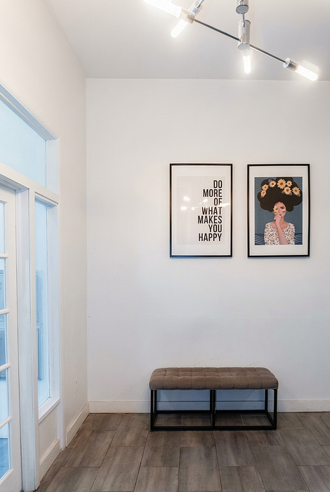 Elegant entryway with modern wall art and sleek lighting, featuring a stylish bench and inviting atmosphere.