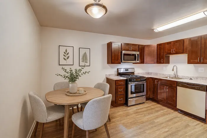 Charming kitchen with modern appliances, sleek wood cabinetry, and cozy dining area, perfect for intimate meals.