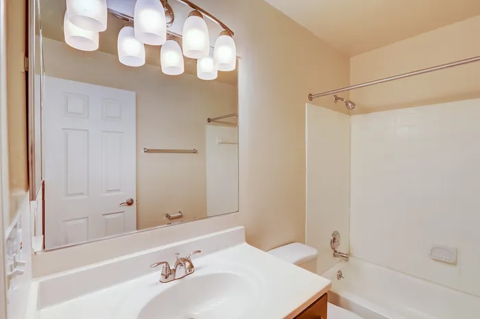 Elegant bathroom with sleek fixtures, warm lighting, and a modern bathtub.