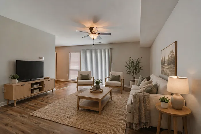 Inviting living room with elegant wooden flooring, cozy seating area, and abundant natural light, perfect for relaxation and entertaining.