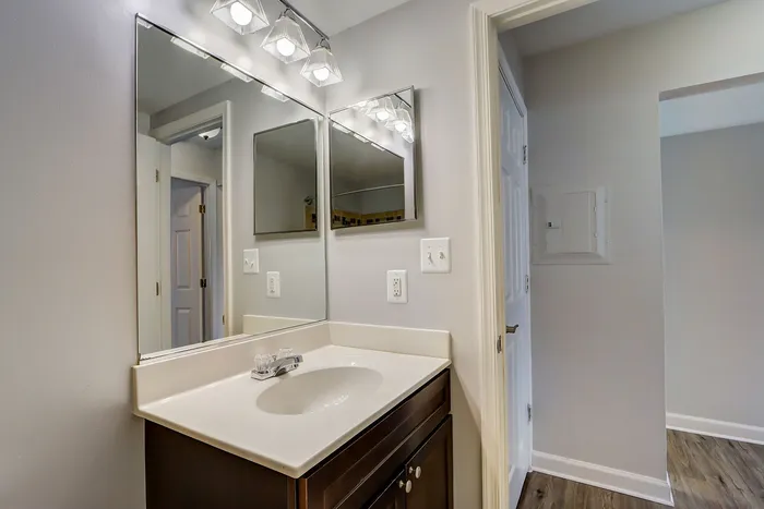 Elegant bathroom with modern mirror fixtures and stylish vanity, featuring a sleek design and bright lighting.