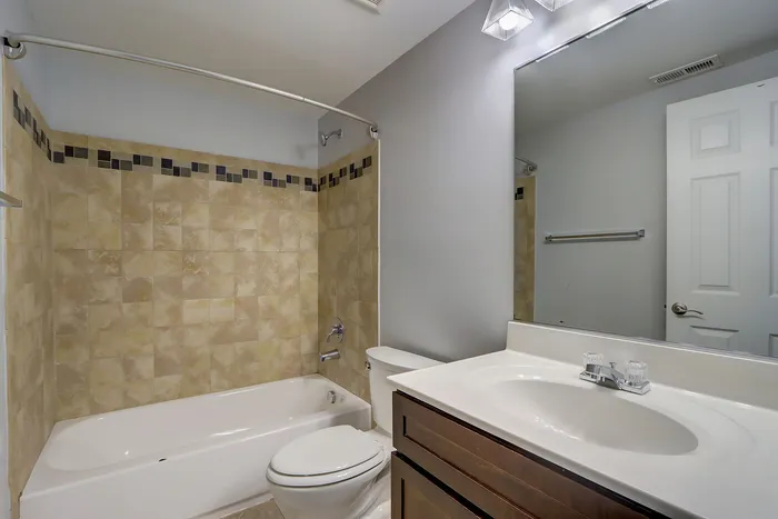 Modern bathroom with elegant tile design, featuring a spacious bathtub, stylish vanity, and contemporary finishes.