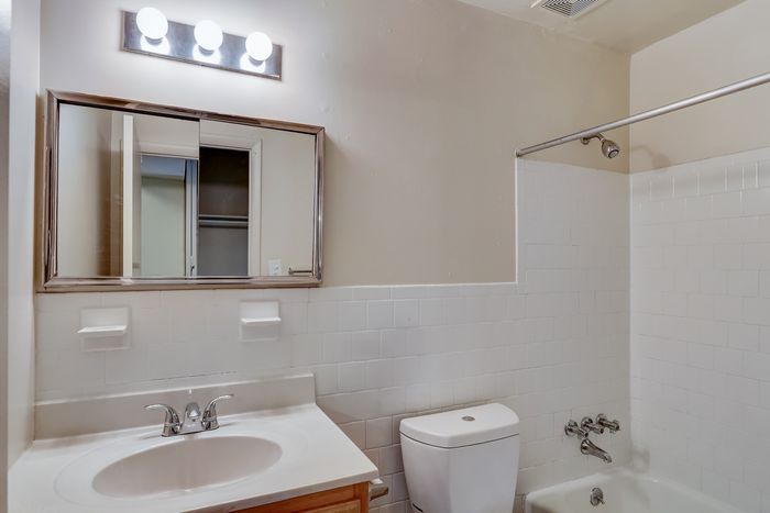 Bright and modern bathroom with a sleek vanity, mirrored cabinet, and elegant light fixtures.
