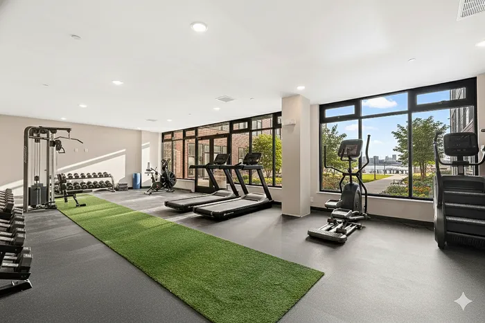 Modern fitness center with state-of-the-art equipment and large windows offering scenic views.