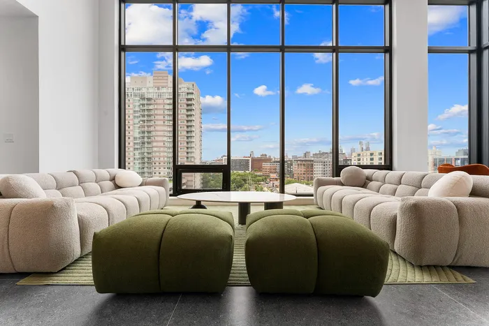 Chic apartment living room with plush sofas, large windows offering stunning cityscape views, and abundant natural light.
