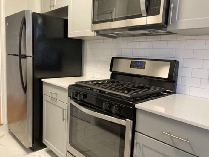 Modern kitchen with sleek stainless-steel appliances, subway tile backsplash, and elegant cabinetry.