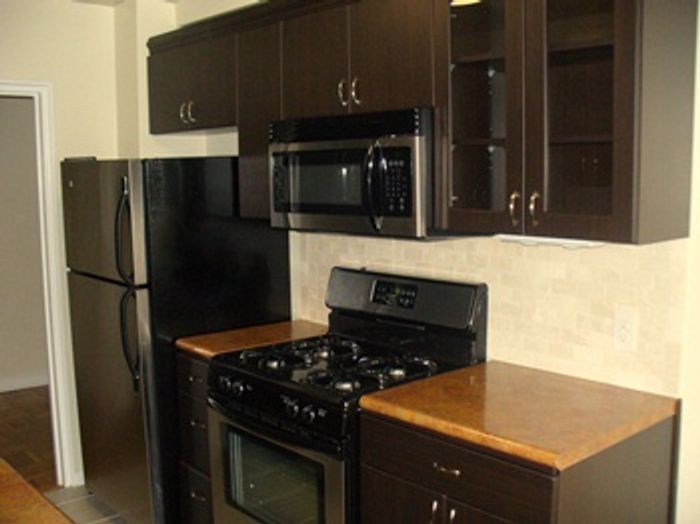 Charming kitchen with modern dark wood cabinets, sleek appliances, and ample counter space.
