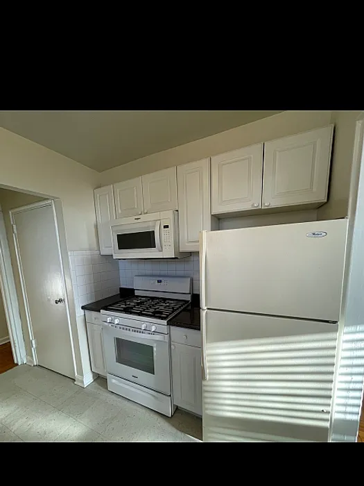 Charming kitchen area with modern white cabinetry, sleek appliances, and ample natural light.