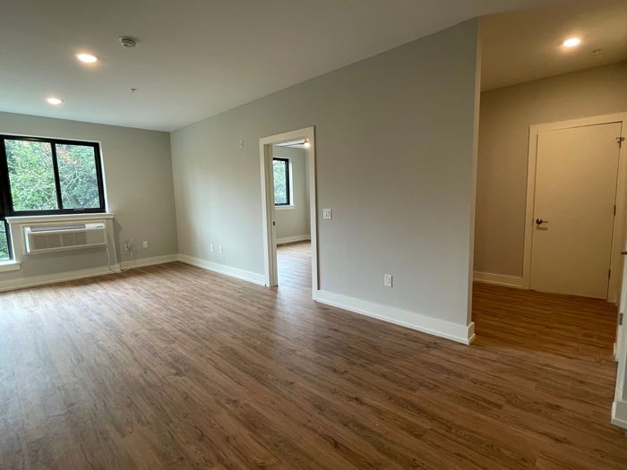 Inviting apartment interior with bright natural light, sleek hardwood floors, and modern finishes.