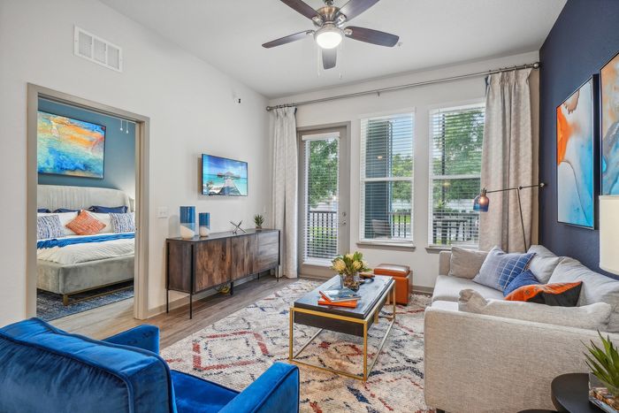 Contemporary living room with abundant natural light, elegant decor, and a cozy adjacent bedroom view.