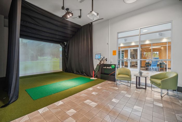 Luxurious indoor golf simulator room with comfortable seating and modern design, perfect for honing your skills at home.