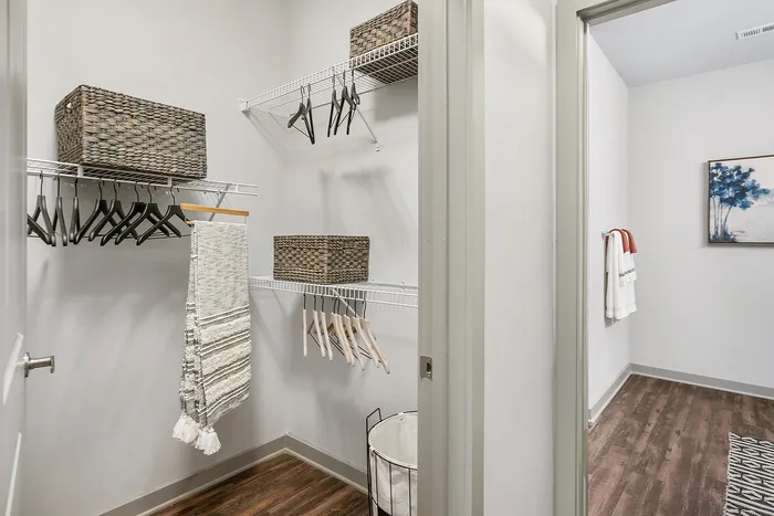 Elegant and spacious walk-in closet with neatly organized shelves, hangers, and stylish storage baskets.